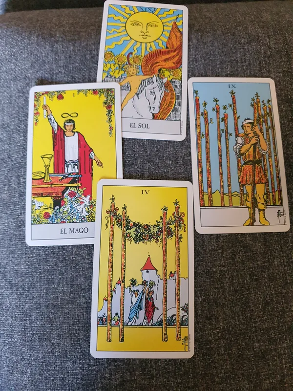 The Sun, The Magician, Nine of Wands and Four of Wands on a grey cloth.